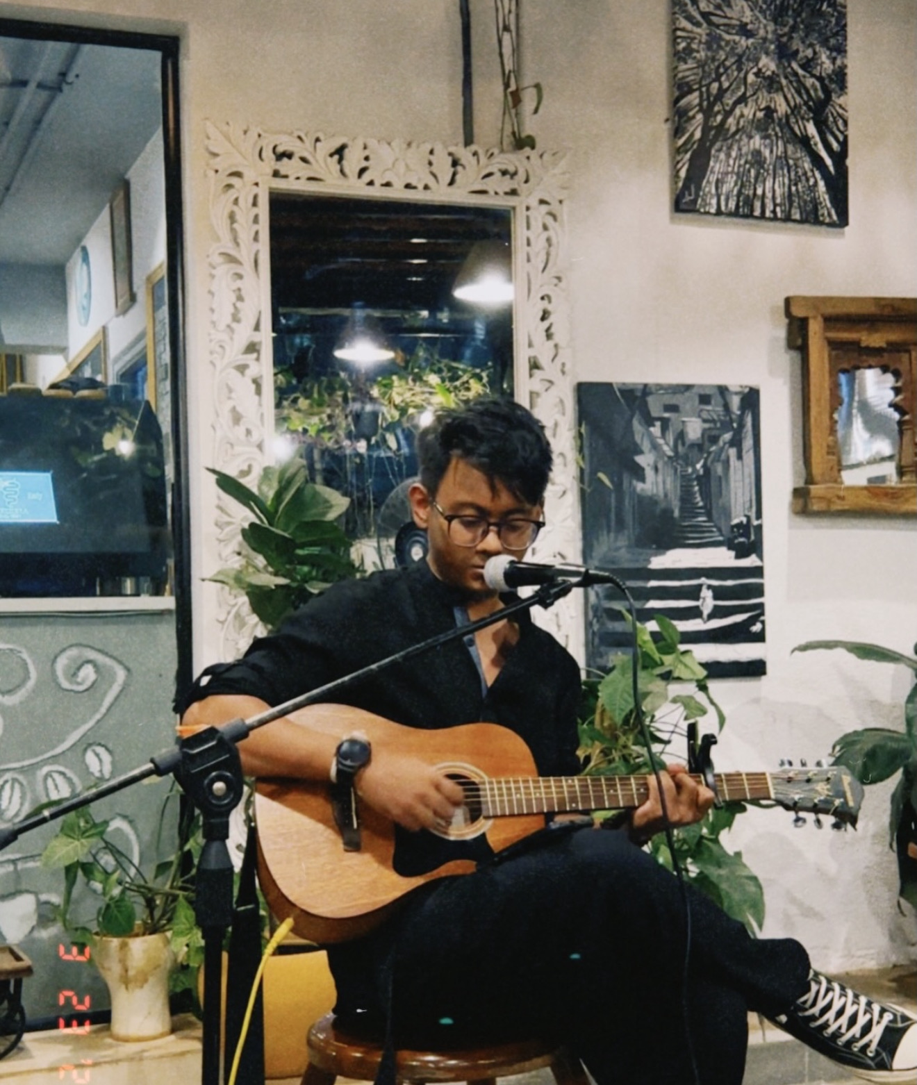 Musician playing acoustic guitar and singing into a microphone