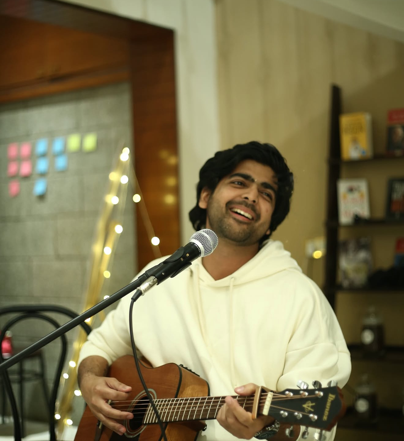 A musician laughing mid-song while playing guitar