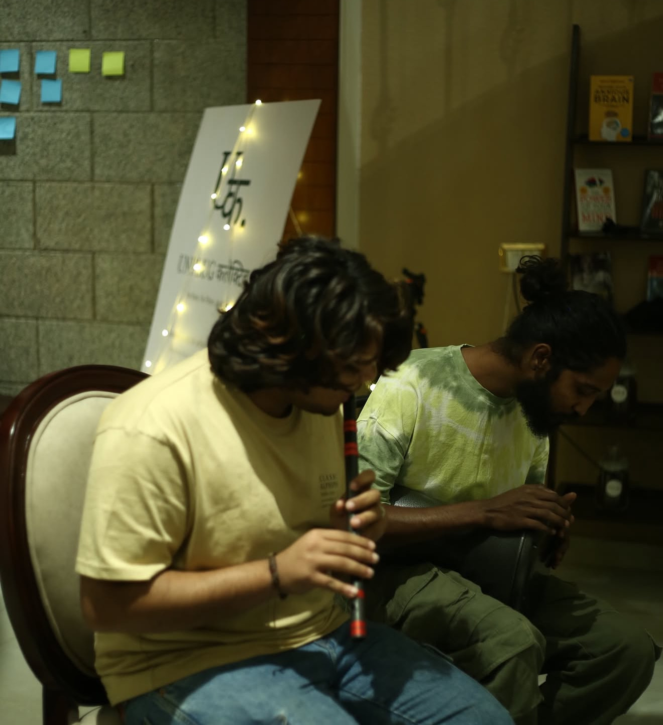 Two musicians backstage near the Unplug Collective sign
